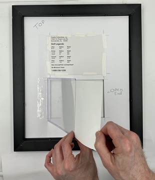 frame back hands holding pic part way into sleeve